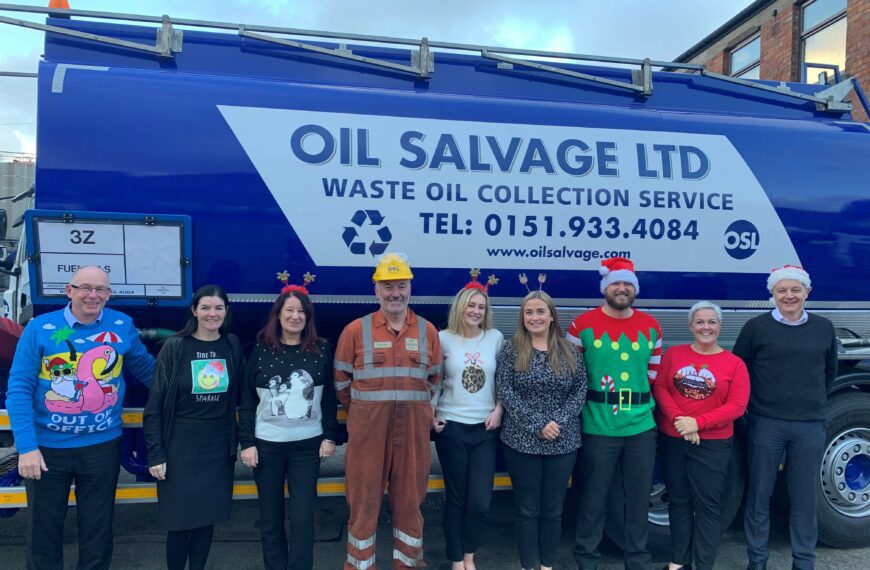 the Oil Salvage team wearing Christmas Jumpers in front of the Oil Salvage Ltd logo